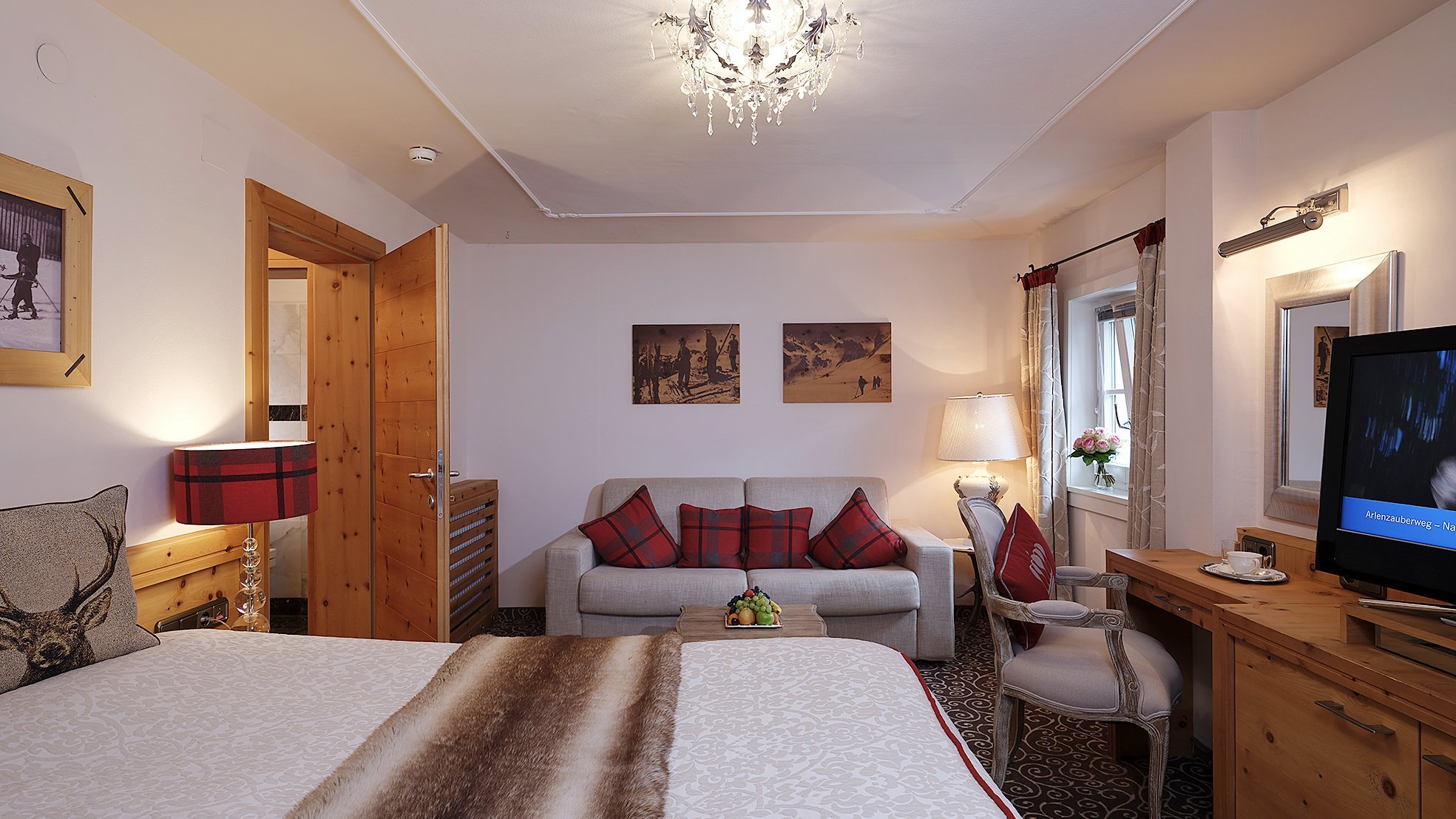 Doppelzimmer Deluxe Elegantes Hotelzimmer mit großem Bett, Sitzecke und Holzelementen in modernem Stil