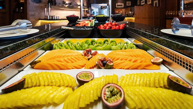 Aufgeschnittene Ananas, Mango, Kiwi und Passionsfrucht am Buffet.
