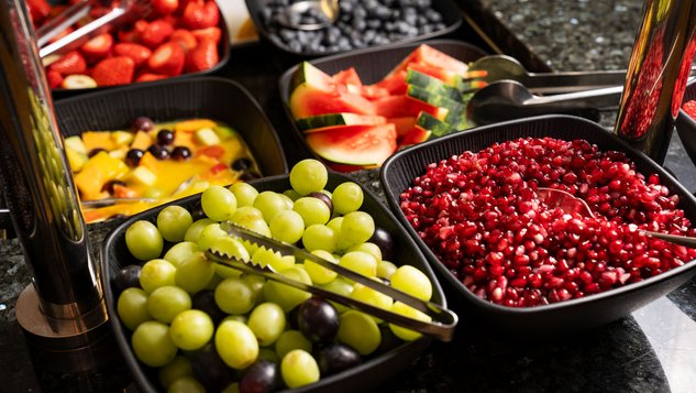 Auswahl an frischem Obst mit Trauben, Melone, Beeren und Ananas.