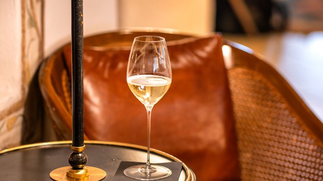 A lounge area featuring a wine glass on a table beside a stylish lamp for relaxation