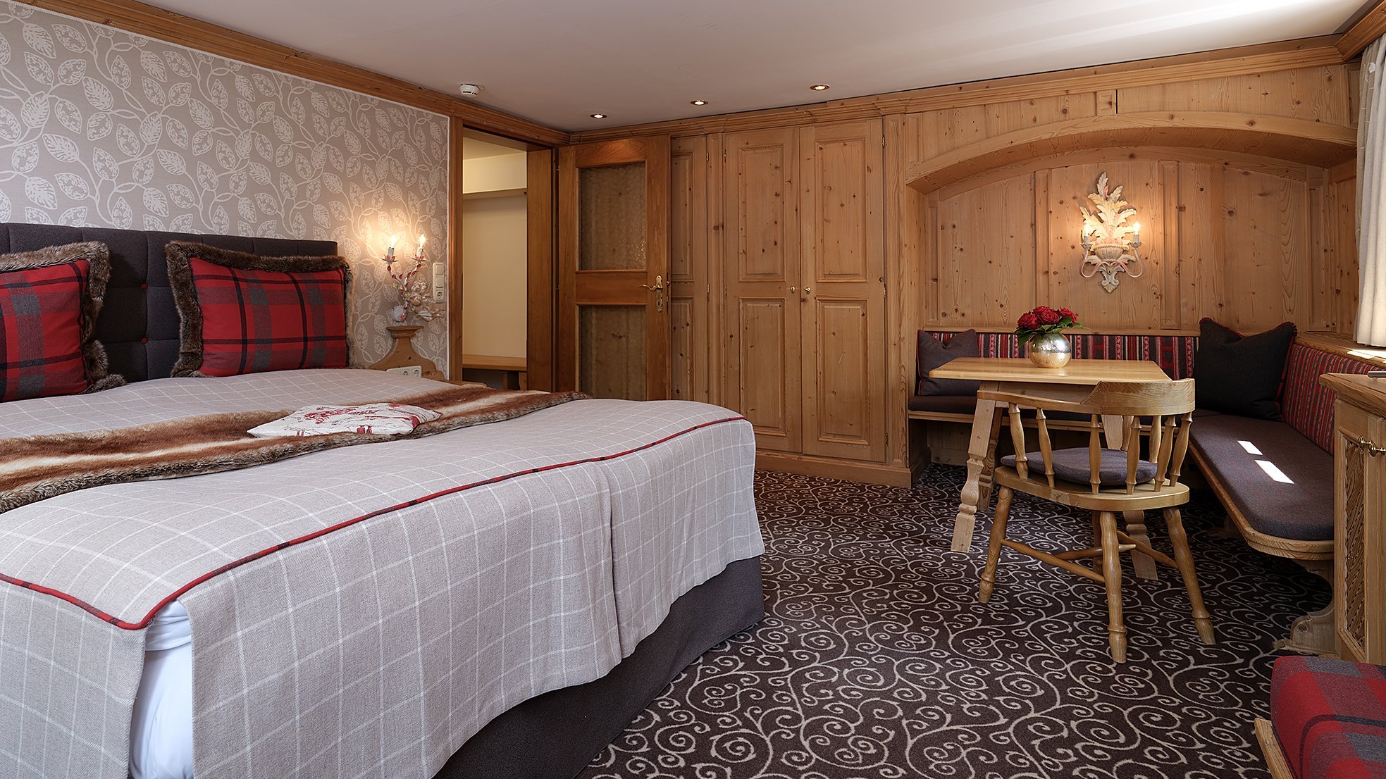 Cozy accommodation featuring a double bed, plaid decor, and a small seating area